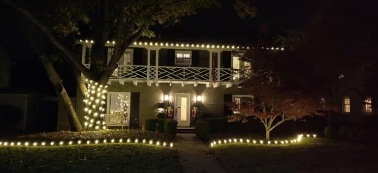 Charming house adorned with festive lights at night, showcasing holiday spirit and decor.