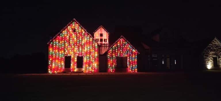 Colorful Christmas lights adorn a house at night, creating a festive holiday atmosphere.