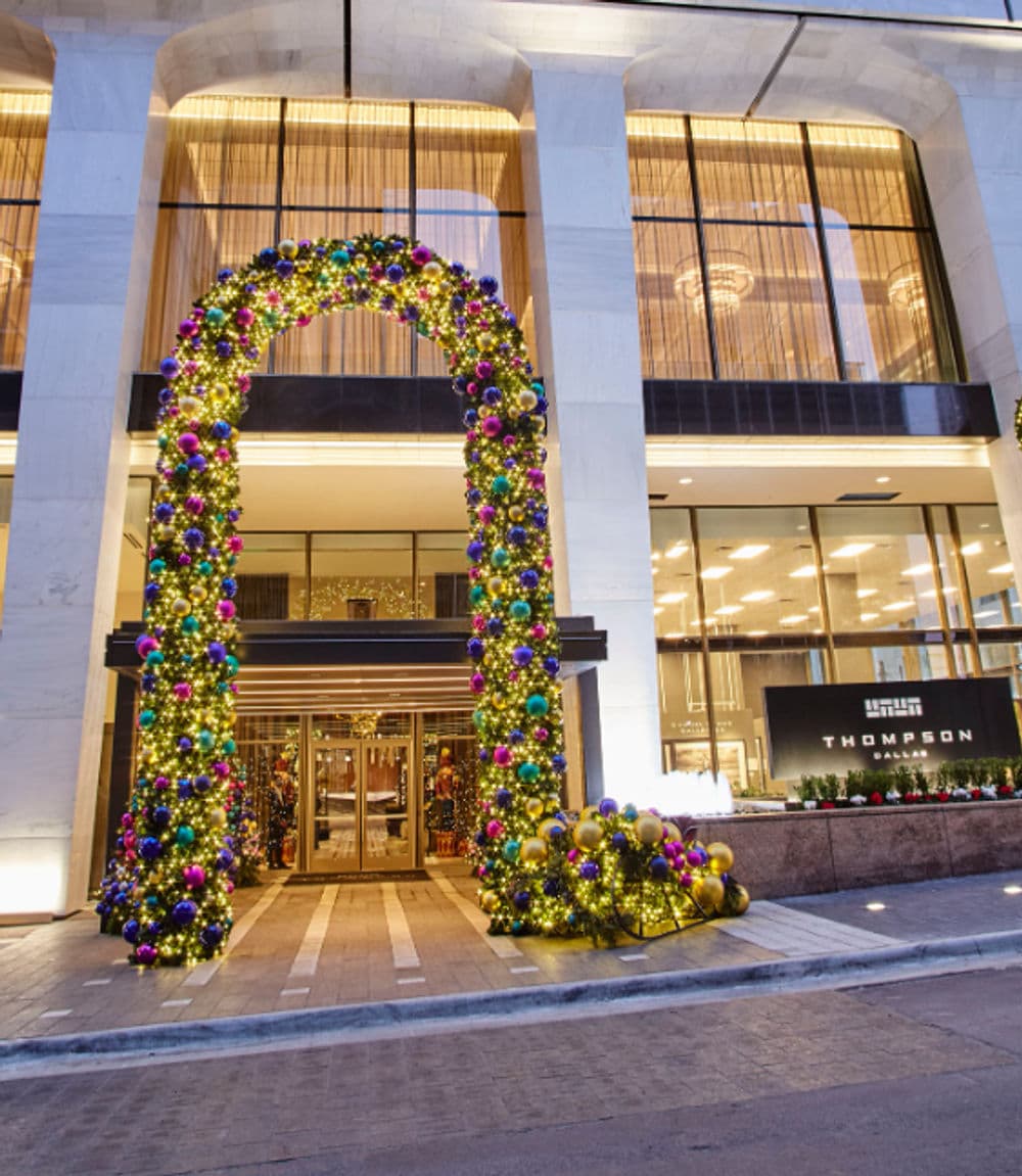 Thompson Hotel entrance decorated with colorful holiday decorations and a festive arch.