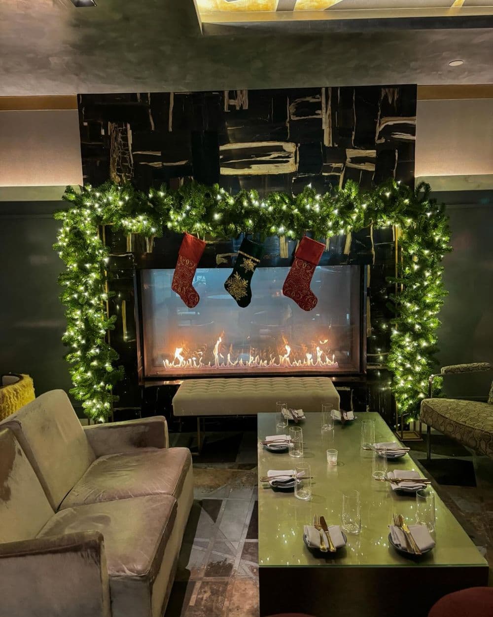 Cozy restaurant interior featuring a festive fireplace with stockings and holiday decor.